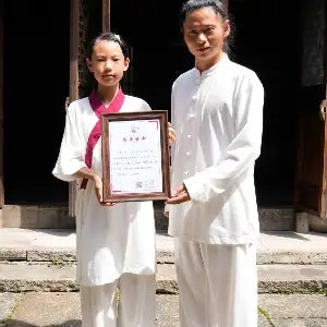 A Tai Chi teacher presenting a certificate of completion to a student